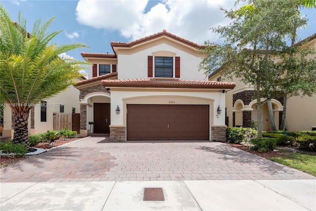 8885 NW 100th Pl, Doral, FL 33178 - mediterranean / spanish house featuring stone siding, stucco siding, decorative driveway, and a tiled roof
