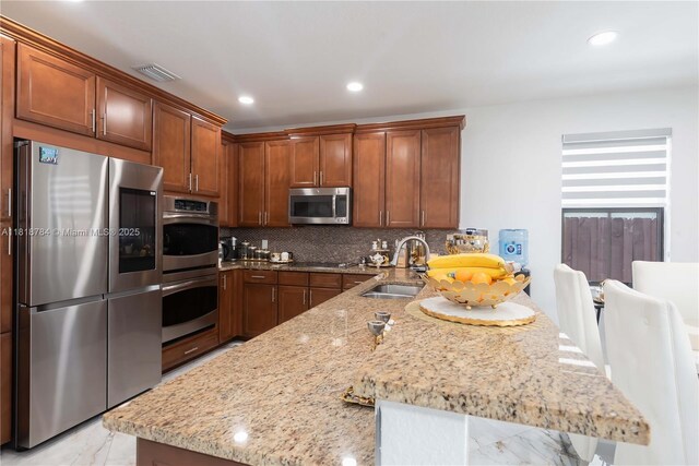 8885 NW 100th Pl, Doral, FL 33178 - kitchen with appliances with stainless steel finishes, a peninsula, light marble finish flooring, light stone countertops, and tasteful backsplash