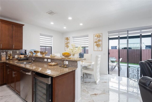8885 NW 100th Pl, Doral, FL 33178 - kitchen featuring wine cooler, a peninsula, light marble finish floors, stainless steel dishwasher, and recessed lighting