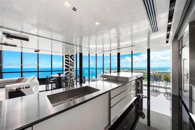 100 S Pointe Dr Unit 3003, Miami Beach, FL 33139 - kitchen featuring expansive windows, white cabinetry, a water view, modern cabinets, and stainless steel countertops