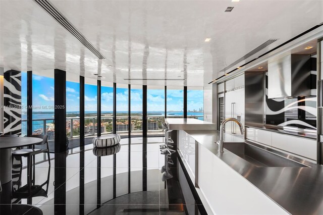 100 S Pointe Dr Unit 3003, Miami Beach, FL 33139 - kitchen with expansive windows, dark tile patterned floors, and a water view