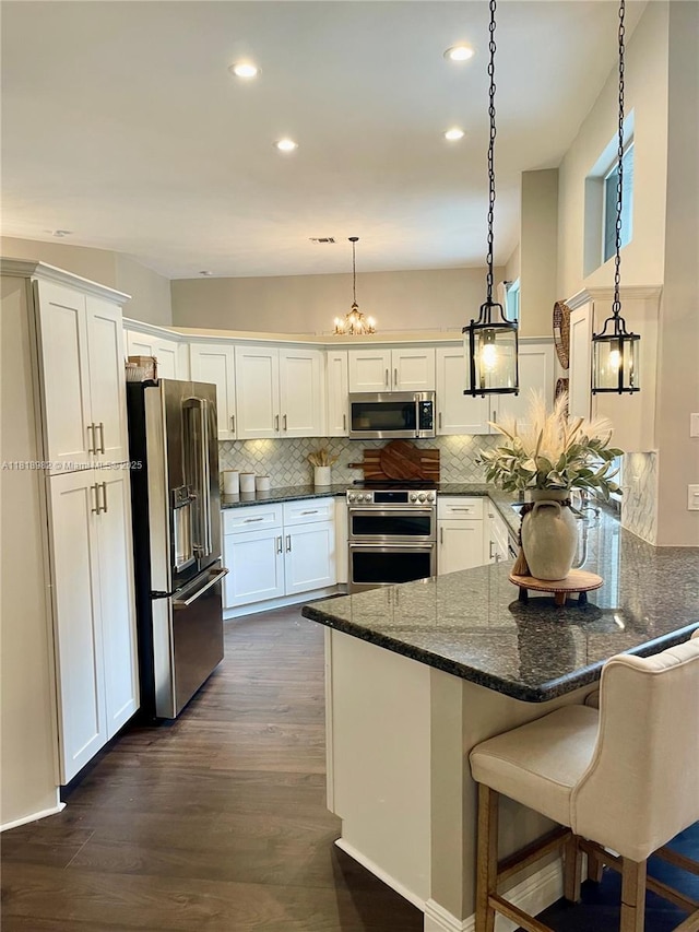 4370 NW 62nd Ter, Coral Springs, FL 33067 - kitchen featuring high quality appliances, recessed lighting, tasteful backsplash, white cabinets, and dark wood-style floors