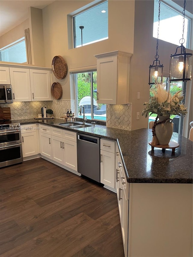4370 NW 62nd Ter, Coral Springs, FL 33067 - kitchen with stainless steel appliances, a peninsula, dark wood-type flooring, white cabinets, and a high ceiling