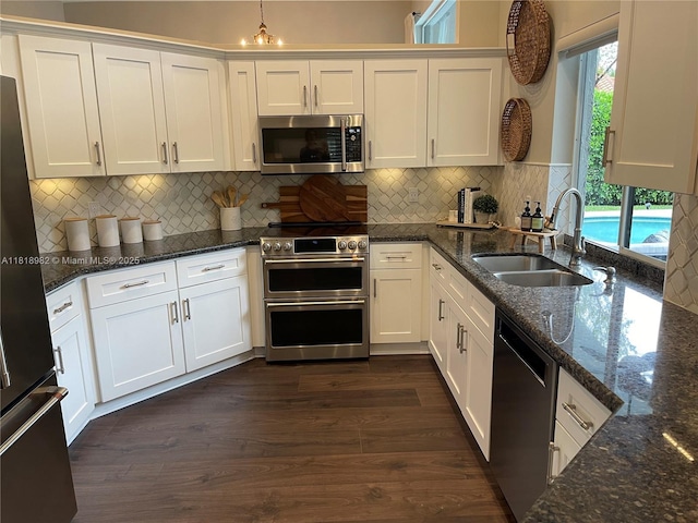 4370 NW 62nd Ter, Coral Springs, FL 33067 - kitchen with stainless steel appliances, white cabinets, dark stone countertops, and backsplash