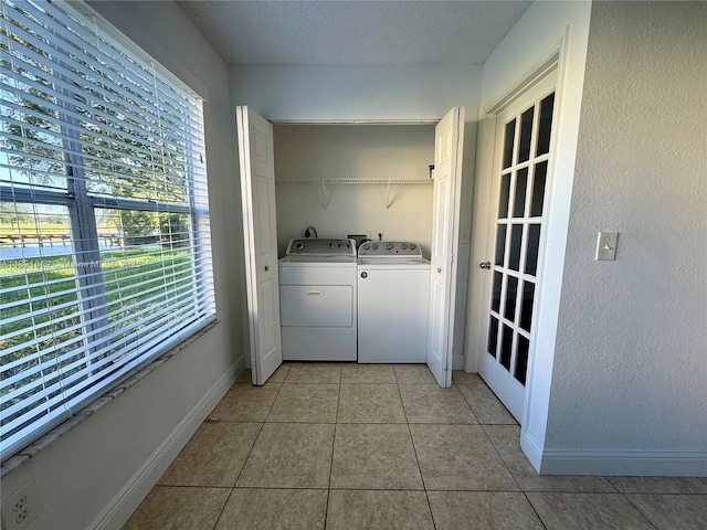 12730 Vista Isles Dr Unit 813, Sunrise, FL 33325 - washroom with washing machine and clothes dryer, light tile patterned flooring, and a textured wall