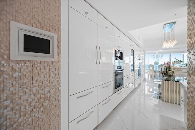 2711 S Ocean Dr Unit 1202, Hollywood, FL 33019 - kitchen featuring white cabinets, a chandelier, modern cabinets, and stainless steel double oven
