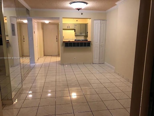 546 SW 1st St Unit 501, Miami, FL 33130 - kitchen with light tile patterned floors, a textured ceiling, ornamental molding, and dark countertops