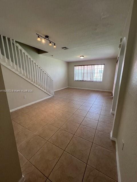 2614 SW 188th Ave, Miramar, FL 33029 - unfurnished room with tile patterned floors, rail lighting, and stairway
