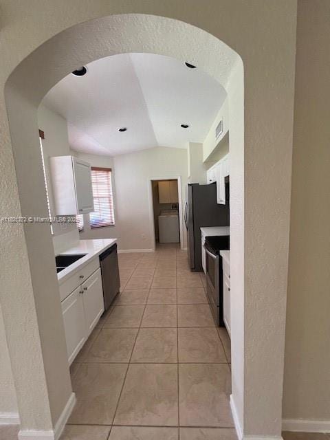 2614 SW 188th Ave, Miramar, FL 33029 - kitchen with washer / clothes dryer, stainless steel appliances, white cabinets, light countertops, and arched walkways