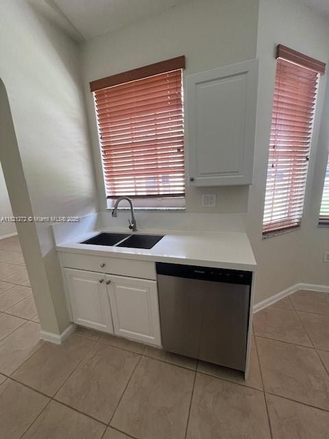 2614 SW 188th Ave, Miramar, FL 33029 - kitchen with stainless steel dishwasher, light tile patterned floors, white cabinetry, and light countertops