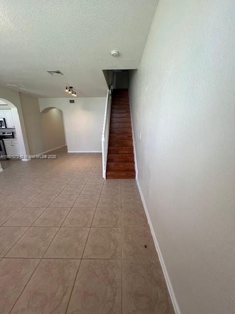 2614 SW 188th Ave, Miramar, FL 33029 - hall featuring arched walkways, light tile patterned floors, a textured ceiling, and stairway