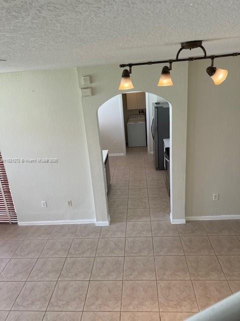 2614 SW 188th Ave, Miramar, FL 33029 - unfurnished room with washer / clothes dryer, arched walkways, light tile patterned floors, and a textured ceiling