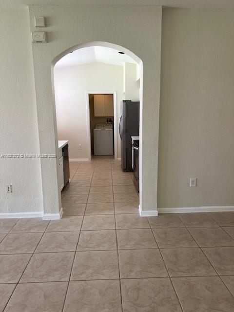 2614 SW 188th Ave, Miramar, FL 33029 - hall with light tile patterned floors, washer / dryer, and arched walkways