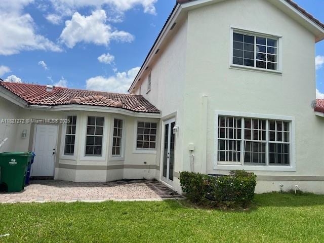 2614 SW 188th Ave, Miramar, FL 33029 - back of house featuring stucco siding, a tiled roof, and a lawn