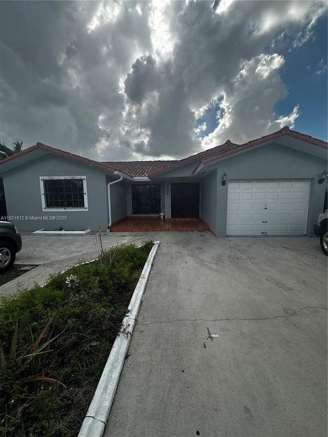 7535 W 5th Ct, Hialeah, FL 33014 - ranch-style home featuring an attached garage, stucco siding, and concrete driveway