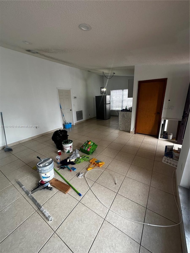 7535 W 5th Ct, Hialeah, FL 33014 - unfurnished living room featuring a textured ceiling and tile patterned flooring