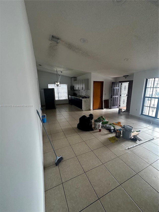 7535 W 5th Ct, Hialeah, FL 33014 - interior space featuring healthy amount of natural light, a textured ceiling, and light tile patterned floors