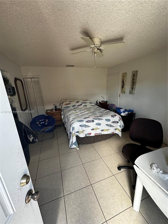 7535 W 5th Ct, Hialeah, FL 33014 - bedroom featuring a closet, a ceiling fan, tile patterned flooring, and a textured ceiling