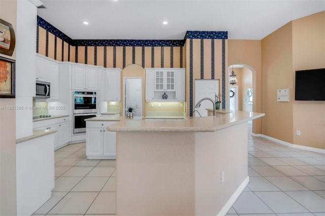 1925 NW 167th Ter, Pembroke Pines, FL 33028 - kitchen featuring a kitchen island with sink, light tile patterned floors, appliances with stainless steel finishes, arched walkways, and recessed lighting