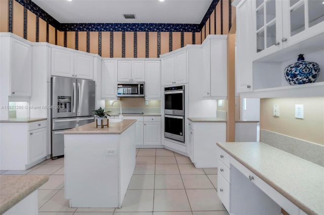 1925 NW 167th Ter, Pembroke Pines, FL 33028 - kitchen with appliances with stainless steel finishes, wallpapered walls, a center island with sink, light countertops, and white cabinetry