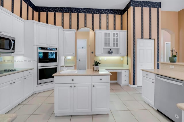 1925 NW 167th Ter, Pembroke Pines, FL 33028 - kitchen featuring appliances with stainless steel finishes, arched walkways, wallpapered walls, light tile patterned floors, and light countertops