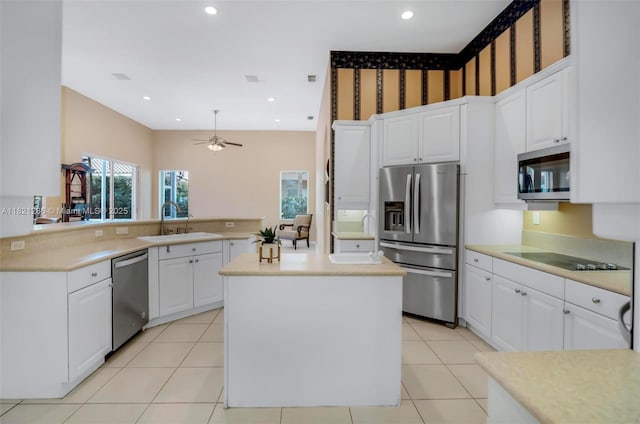 1925 NW 167th Ter, Pembroke Pines, FL 33028 - kitchen featuring stainless steel appliances, a peninsula, light countertops, a ceiling fan, and wallpapered walls