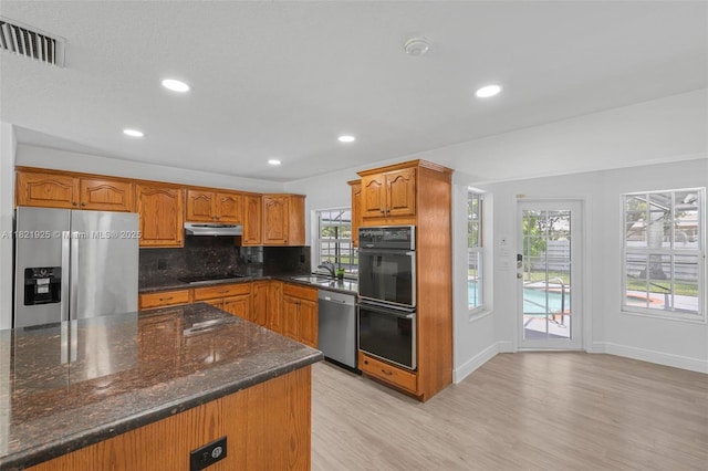 14821 SW 148th St Cir, Miami, FL 33196 - kitchen with black appliances, under cabinet range hood, light wood finished floors, tasteful backsplash, and brown cabinets