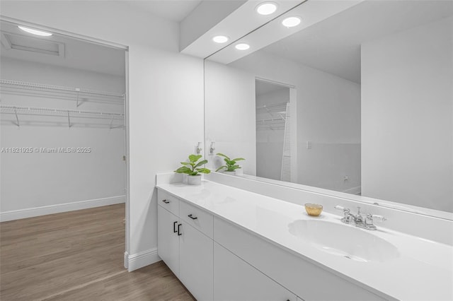 14821 SW 148th St Cir, Miami, FL 33196 - bathroom featuring vanity, a walk in closet, recessed lighting, and wood finished floors