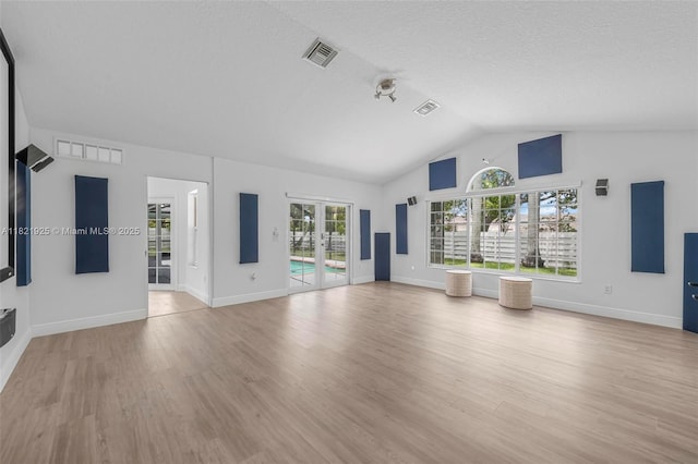14821 SW 148th St Cir, Miami, FL 33196 - unfurnished living room with lofted ceiling, wood finished floors, and a textured ceiling