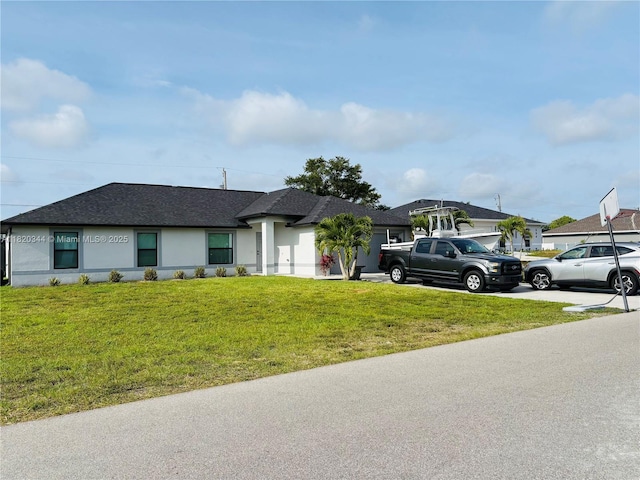 500NW 5 Th St, Cape Coral, FL 33993 - ranch-style house with a front lawn, a shingled roof, stucco siding, an attached garage, and concrete driveway