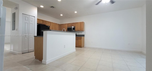 975 NE 42nd Pl, Homestead, FL 33033 - kitchen with stainless steel microwave, freestanding refrigerator, recessed lighting, light tile patterned floors, and electric panel