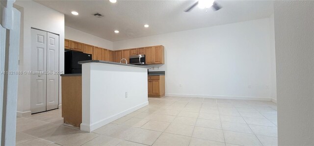 975 NE 42nd Pl, Homestead, FL 33033 - kitchen with stainless steel microwave, freestanding refrigerator, recessed lighting, light tile patterned flooring, and ceiling fan