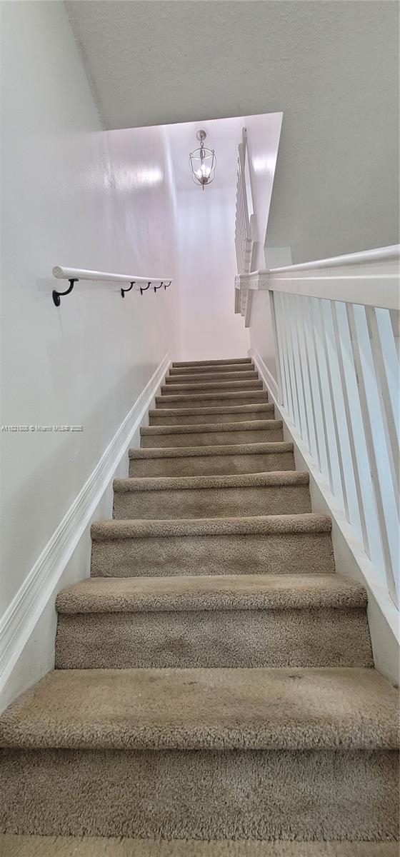 975 NE 42nd Pl, Homestead, FL 33033 - staircase featuring a chandelier