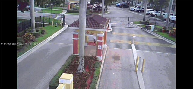 975 NE 42nd Pl, Homestead, FL 33033 - view of asphalt road featuring curbs and a gated entry