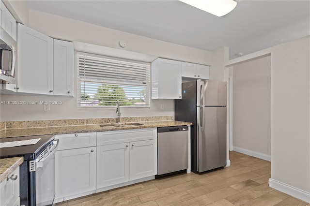 421 SW 64th Ter, Margate, FL 33068 - kitchen featuring appliances with stainless steel finishes, white cabinets, light wood-style flooring, and light stone counters