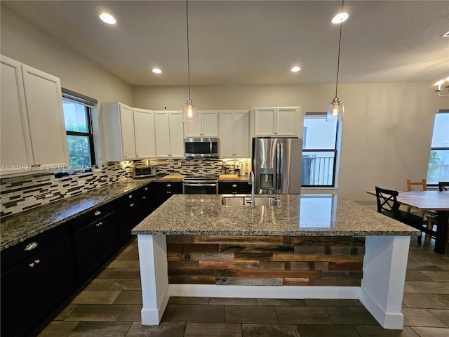 3238 W 96th Pl, Hialeah, FL 33018 - kitchen featuring appliances with stainless steel finishes, plenty of natural light, backsplash, dark stone counters, and recessed lighting