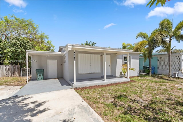 5288 N Andrews Ave, Oakland Park, FL 33309 - view of front of house featuring an attached carport, driveway, a porch, and stucco siding