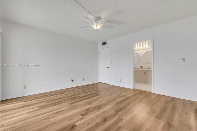 2504 Antigua Ter Unit L4, Coconut Creek, FL 33066 - unfurnished bedroom featuring light wood-style flooring, ensuite bathroom, a textured ceiling, and a ceiling fan