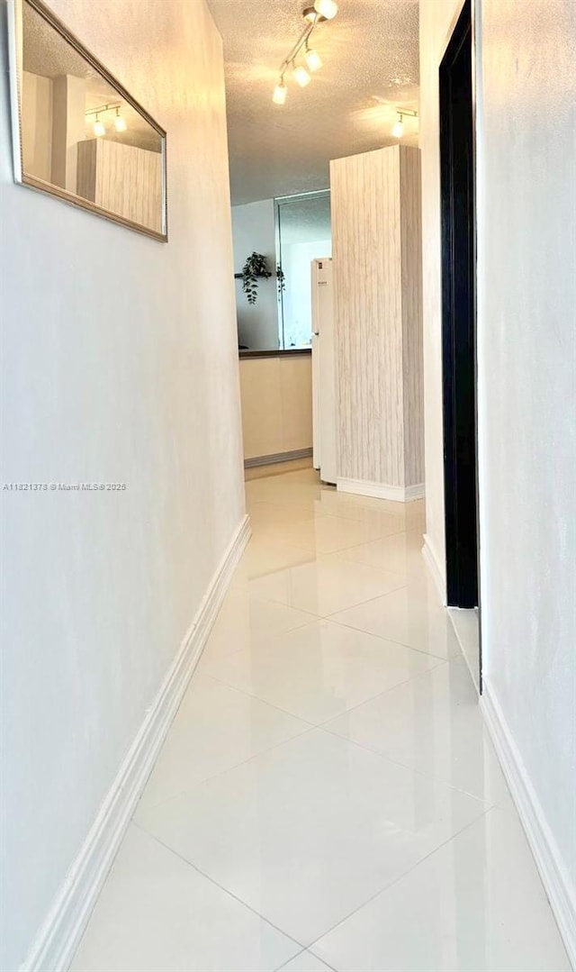 1936 S Ocean Dr Unit 7C, Hallandale Beach, FL 33009 - corridor with rail lighting, light tile patterned floors, and a textured ceiling