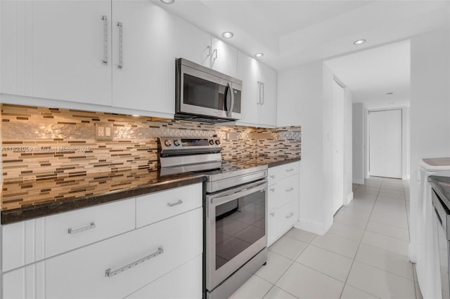 1901 Brickell Ave Unit B1508, Miami, FL 33129 - kitchen with appliances with stainless steel finishes, dark countertops, light tile patterned floors, white cabinetry, and recessed lighting