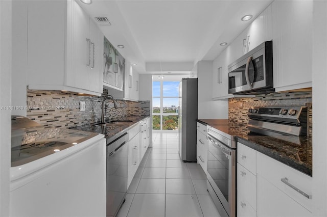 1901 Brickell Ave Unit B1508, Miami, FL 33129 - kitchen featuring appliances with stainless steel finishes, tasteful backsplash, white cabinetry, recessed lighting, and light tile patterned flooring