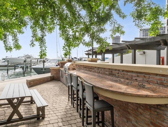 1901 Brickell Ave Unit B1508, Miami, FL 33129 - view of patio / terrace with a water view, exterior bar, a boat dock, exterior kitchen, and boat lift