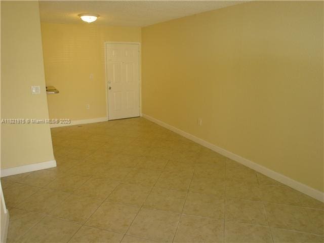 8185 NW 7th St Unit 316, Miami, FL 33126 - empty room featuring light tile patterned floors and baseboards