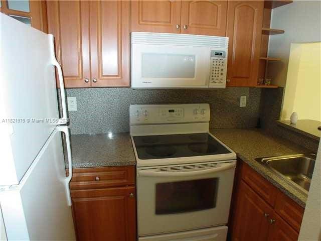 8185 NW 7th St Unit 316, Miami, FL 33126 - kitchen with white appliances, open shelves, decorative backsplash, and brown cabinetry