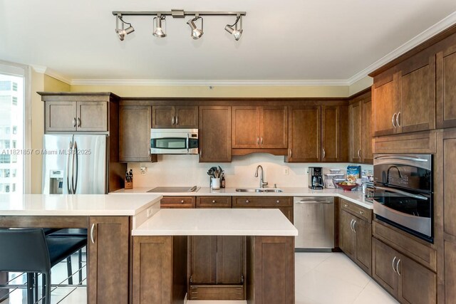 300 S Pointe Dr Unit 1602, Miami Beach, FL 33139 - kitchen with appliances with stainless steel finishes, ornamental molding, light countertops, a center island, and a kitchen breakfast bar
