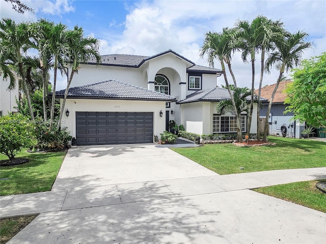 16132 SW 147th Ln, Miami, FL 33196 - mediterranean / spanish house with an attached garage, a front yard, driveway, stucco siding, and a tiled roof