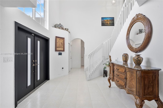 16132 SW 147th Ln, Miami, FL 33196 - foyer featuring a high ceiling, arched walkways, stairs, and light tile patterned floors