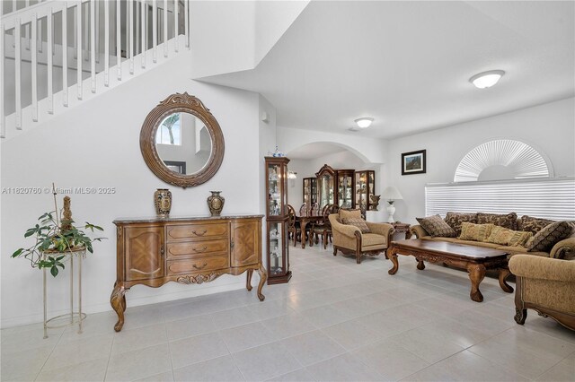 16132 SW 147th Ln, Miami, FL 33196 - living room featuring arched walkways, light tile patterned flooring, and stairs