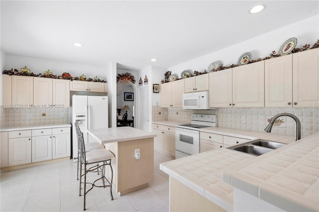 16132 SW 147th Ln, Miami, FL 33196 - kitchen with white appliances, tile counters, backsplash, a center island, and a breakfast bar area