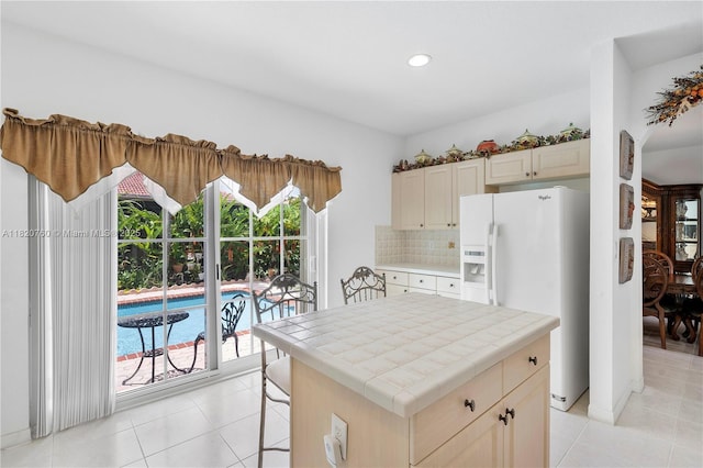 16132 SW 147th Ln, Miami, FL 33196 - kitchen with tile counters, white fridge with ice dispenser, light tile patterned floors, recessed lighting, and decorative backsplash
